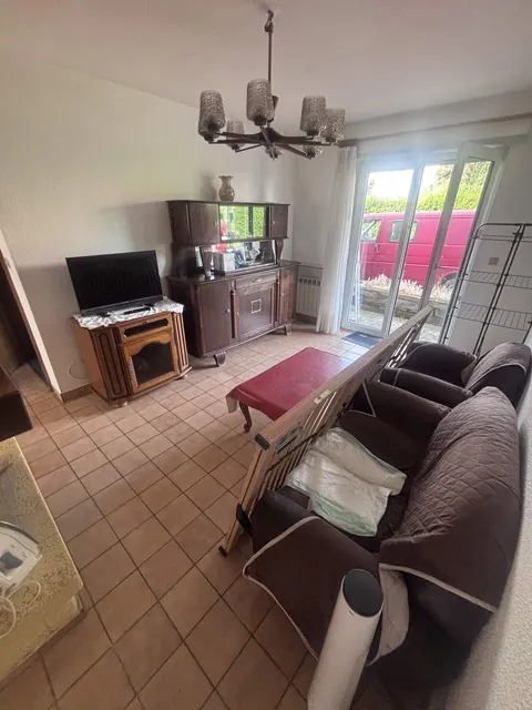 Séjour encombré de meubles et d'objets avant l'intervention.